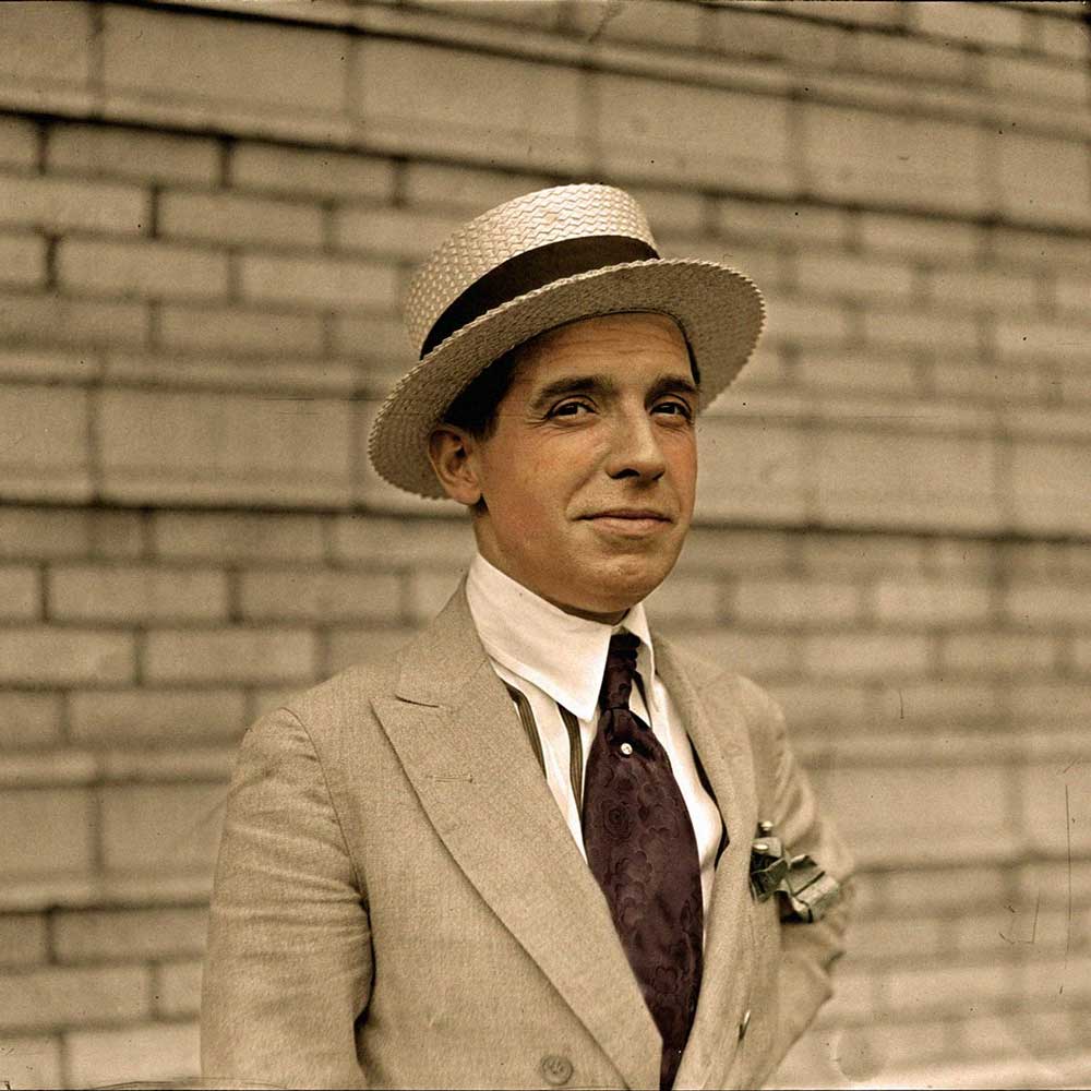 Ponzi, Male standing in suit with hat on smiling at camera. 